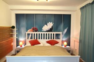 a bedroom with a large bed with red pillows at Ferienwohnungen Halbturn in Halbturn