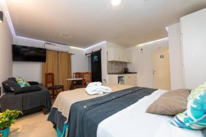 een slaapkamer met een groot bed en een stoel bij Ohana Apart Hotel in Termas de Río Hondo