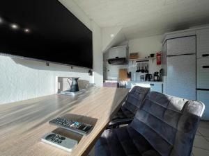 a living room with a table with a television on the wall at Moselgarten Bullay Zentral Grün Direkt an der Mosel in Bullay