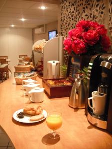 a counter with a coffee maker and a glass of orange juice at Séjours & Affaires Tours Léonard De Vinci in Tours