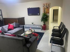 a living room with a couch and chairs and a tv at Sabbath Lodge VIP in Cape Town +33 photos
