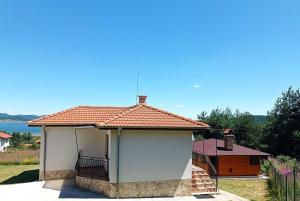 a small white building with a balcony on top at Вила Хоризонт in Tsigov Chark