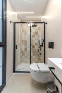 a bathroom with a shower and a white toilet at Apartamentos La Basílica by BeAlicante in Alicante