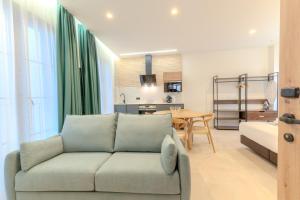a living room with a couch and a kitchen at Apartamentos La Basílica by BeAlicante in Alicante