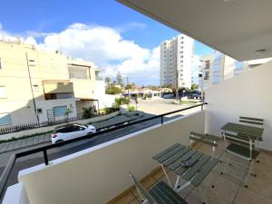un balcón con sillas y un coche blanco en una calle en Cozy 2BR Beach Apt, Perfect for Getaways, en Lárnaca