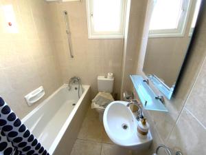 Un baño con lavabo, bañera e inodoro. en Cozy 2BR Beach Apt, Perfect for Getaways, en Lárnaca