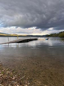 a dock on a body of water on a cloudy day at Apartament w Zagrodzie in Frydman