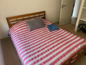 a bed with a striped comforter in a bedroom at Depto completo hasta 5 personas in Los Andes +15 photos