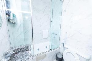 een witte badkamer met douche en toilet bij Ohana Apart Hotel in Termas de Río Hondo +19 foto's