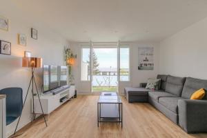 a living room with a couch and a tv at L'Escale, Appartement 2 chambres avec Balcon, Villefranche in Villefranche-sur-Saône