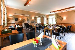 a restaurant with tables and chairs in a room at Hotel Reinhold in Gummersbach