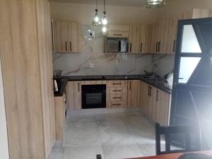 a kitchen with wooden cabinets and a stove top oven at Sabbath Lodge VIP in Cape Town