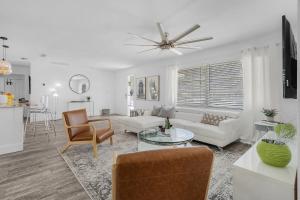 a living room with a couch and a ceiling fan at Gulf Access, Heated Pool, Dock, Lanai -Sunset Coast Bungalow - Roelens in Cape Coral