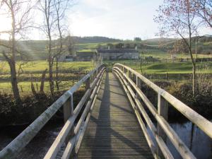 a bridge over a river with a person on it at 7 Front Street in Saint Johns Chapel