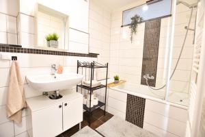a white bathroom with a sink and a shower at Ferienwohnung Karl in Dessau +24 photos