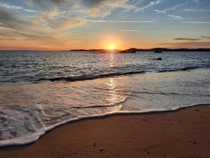 a sunset on the beach with the shoreline at Zephyros in Paraga