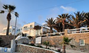 a stone wall with palm trees and buildings at Zephyros in Paraga