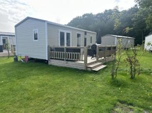 a small house with a deck in a yard at Huis Meerwijck in Gasselte