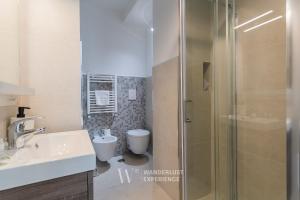 a bathroom with a shower and a sink and a toilet at Wanderlust Experience Pumetta Apartment in Bitonto +16 photos
