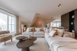 Una sala de estar con un sofá grande y una mesa. en Seaholiday Nieuwpoort met zicht op de jachthaven, en Nieuwpoort