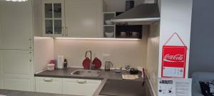 a kitchen with a sink and a cocacola sign on the wall at Stella Maris in Desenzano del Garda +13 photos