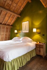 a bedroom with a large white bed with a green wall at B&B Canal Deluxe in Bruges