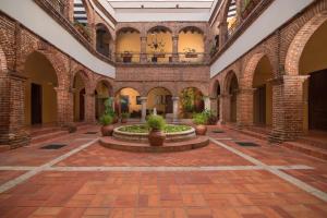 a courtyard in a building with a fountain at Hodelpa Nicolás de Ovando in Santo Domingo