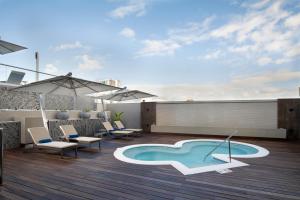 un patio con sillas y una piscina en la azotea en Hodelpa Gran Almirante, en Santiago de los Caballeros
