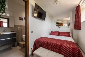 a bedroom with a red and white bed and a bathroom at Casa di Eva in Pisa