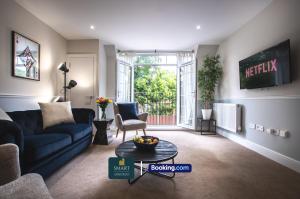 Una sala de estar con un sofá azul y una mesa. en 2 Bedroom Apartments By Smart Apartments Short Lets & Serviced Accommodation Apartment Southampton With Free WiFi, en Southampton
