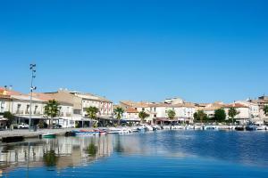 a marina with boats in the water and buildings at Appartement bord d'etang in Poussan