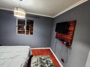 a bedroom with a bed and a flat screen tv at Donde PATO in Iquique