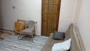een woonkamer met een bank en een stoel bij siwa shaly hostel 3 in Siwa