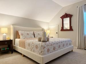 a bedroom with a large bed and a mirror at Charming Cottage for Family and Dogs near Beach & City in Savannah