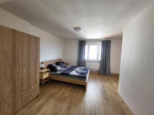 una camera da letto con un letto e un pavimento in legno di City Center Apartments - Moderna Brno Římské náměstí V a Brno