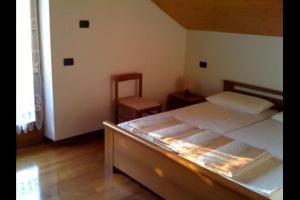 a bedroom with a bed and a chair in it at Casa Bezzi in Pellizzano