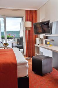 a hotel room with a bed and a desk with a television at Landgasthof Eiserner Ritter in Boppard