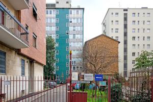 a city street with tall buildings and a fence at Ecoloft in Corso Como con parcheggio privato e gratuito in Milan