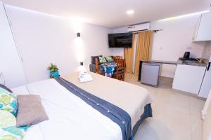 een slaapkamer met een groot bed en een keuken bij Ohana Apart Hotel in Termas de Río Hondo