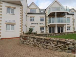a large white house with a stone wall at Apartment 6 in Newquay