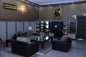 a living room with couches and a table and a tv at Diana Palace Hotel in Diyānah