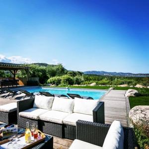 patio z wiklinowymi meblami obok basenu w obiekcie La Villa Cilagna w mieście Cirendinu
