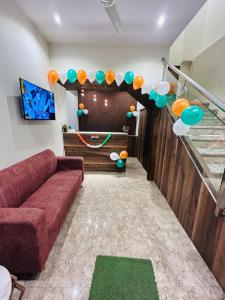 a living room with a red couch and balloons at Hotel Metro Inn in Mumbai +50 photos