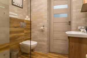 a bathroom with a toilet and a sink at VacationClub - Osiedle Belweder Apartament 1 in Wisła