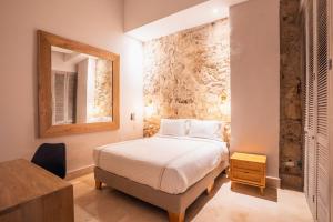 una camera con letto, specchio e tavolo di Casa Catalina De Mokana By SoHo a Cartagena de Indias Altre 35 foto