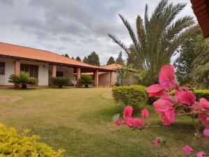 a house with a yard with pink flowers at Recanto da Família in Quadra