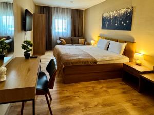 索非亚Apartments Sofia Airport free shuttle and parking的一间卧室,配有一张床、一张书桌和一张沙发