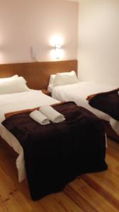 
a hotel room with two beds and two nightstands at Martim Moniz 28 Guest House in Lisbon
