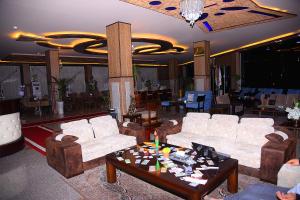 a living room with couches and a coffee table at Diana Palace Hotel in Diyānah