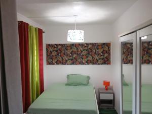 a bedroom with a bed and a pendant light at Appartement au cœur de jambette in Saint-Joseph